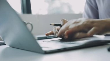 Dizüstü bilgisayarda çalışan genç adam.