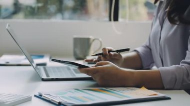 İş kadını ofiste dizüstü bilgisayar ve tablet bilgisayarla çalışıyor.