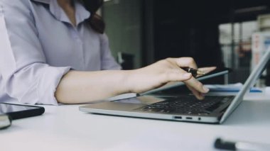 Genç iş kadını ofiste dizüstü bilgisayarda çalışma
