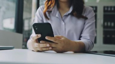 Akıllı telefon tutan ve cep telefonu kullanan iş kadını