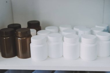 Eczane rafları, ilaç şişeleri, güneş ışığı, sağlık hizmetleri.