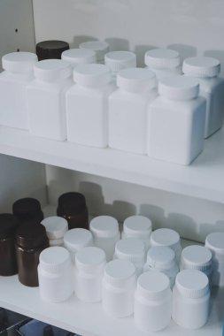 Eczane rafları, ilaç şişeleri, güneş ışığı, sağlık hizmetleri.