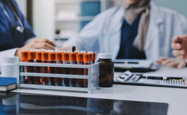 Erkek ve kadın doktorlar bir hastane odasında toplantı yapıyorlar..