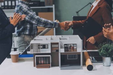 İnşaat, planlama ve mimarlar inşaat, strateji ve endüstriyel işbirliği konularında toplanıyorlar. Mimarlık işçileri kağıt ve modelle bakım projesinden bahsediyorlar.