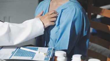 Kadın doktor elinde şırınga tutuyor.