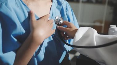 Doktor steteskop tutuyor ve hastanın kalbini kontrol ediyor.