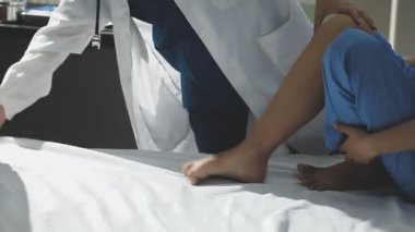 Doktor hastanede bacağını muayene ediyor.