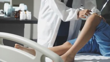 Kadın doktor klinikte steteskopla hastayı muayene ediyor.