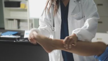 Kadın doktor el ile hastaya dokunuyor.