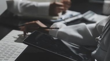 Bilgisayarlı ve iş yerindeki akıllı telefonlu genç işadamlarına yakın çekim