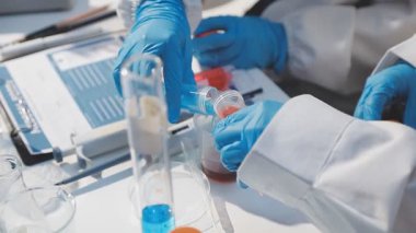 Laboratuvar önlüklü bilim adamı elinde test tüpü tutuyor.