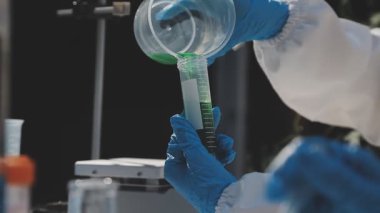 Kapat. Laboratuvarda deney tüpü tutan bilim adamı.