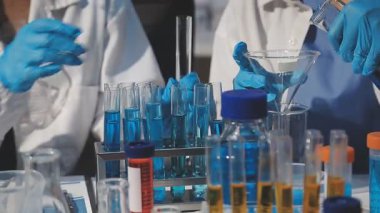 Laboratuvarda sıvı tüple kimyasal deney yapan bilim adamı.