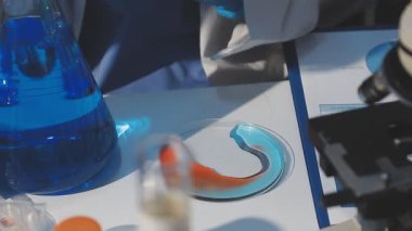 Farklı sıvılara sahip laboratuar asistanı.