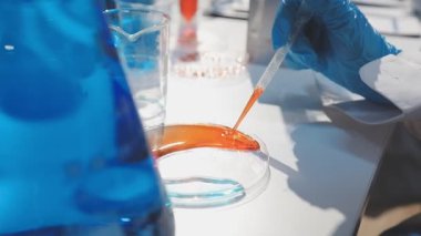 Laboratuvar test tüpünü kapatın. Masada mavi sıvı olsun. Arka planda bulanık cam olsun. Bilim, kimya, çalışma, araştırma