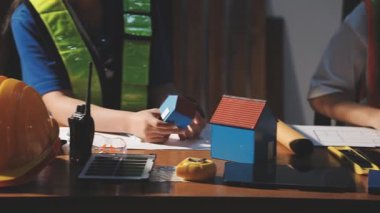 Miğferli, üniformalı ve kasklı genç bir kadın evde dizüstü bilgisayarla çalışıyor.,