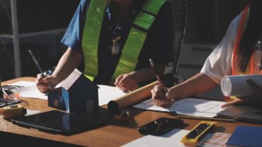 Bina planı ve inşaat projesiyle çalışan mühendis veya mimar.