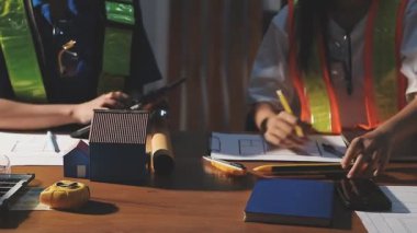 Asyalı mühendis ya da mühendis çalışma masasında planla çalışıyor. İnşaat mühendisi, mühendis, mühendis veya inşaat alanında çalışan mühendis veya mühendis.