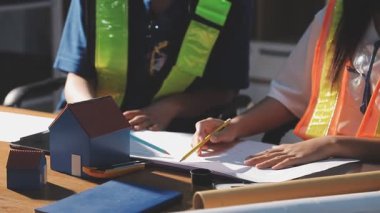 Ev, inşaat, mühendislik ve mühendislik konularında planları olan Asyalı genç bir mimar.