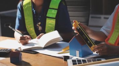 Asyalılar inşaat planı, plan ve çizim üzerinde kalem, plan, mühendislik, mimari ve inşaat konseptiyle çalışıyorlar..