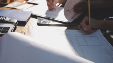 Ofiste planlarla çalışan bir mimar..