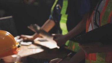 Miğferli mühendis, iş yerindeki planlarla çalışıyor..