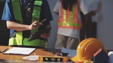 İş yerinde miğferi ve planı olan bir inşaat işçisi.