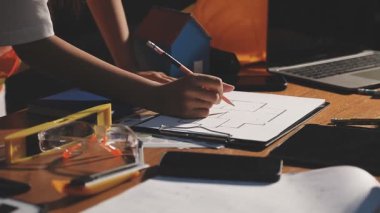 Dişi elleri kalem ve hesap makinesiyle ahşap arka planda kapatın.