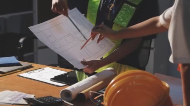 İnşaat alanında planlar üzerinde çalışan mimar mühendisi, inşaat konsepti