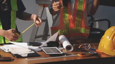 Ofiste dizüstü bilgisayar ve inşaat araçlarıyla çalışan mühendis