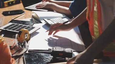 Masada dizüstü bilgisayar ve inşaat araçlarıyla çalışan mühendis.