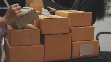 Kadın elinde karton kutuyla bir sürü şey tutuyor.