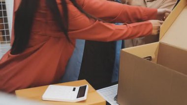 Karton bir kutu taşıyan bir kadın.