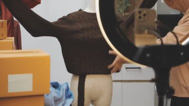 Kadın evde kıyafetlerin fotoğrafını çekiyor.