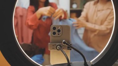 Kadın eli oturma odasında video akışı olan akıllı bir telefonu tutuyor..