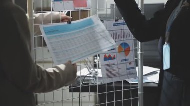 İş adamları iş grafikleri ve grafikleri tartışıyor