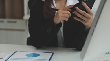 Genç iş kadını ofiste dizüstü bilgisayarla çalışıyor.