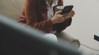 Evde cep telefonu kullanan Asyalı kadın.