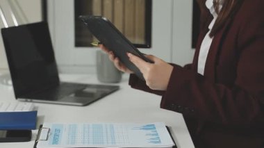 Dizüstü bilgisayarı ve evrakları olan bir iş kadını.