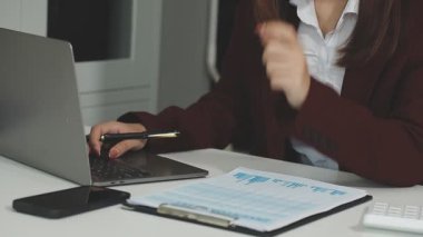 Masada dizüstü bilgisayar ve hesap makinesi kullanan bir iş kadını. iş ve finans kavramı.