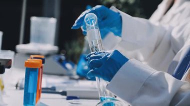 Bilim adamının elinde test tüpü varken kameraya bakması.