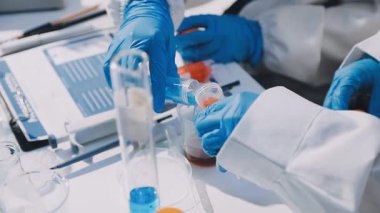 Laboratuvarda çalışan koruyucu eldivenli bilim adamları