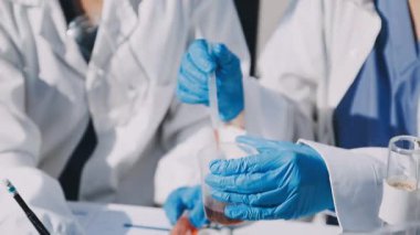 Laboratuvarda koruyucu eldivenleri olan bilim adamı tüpü tutuyor.