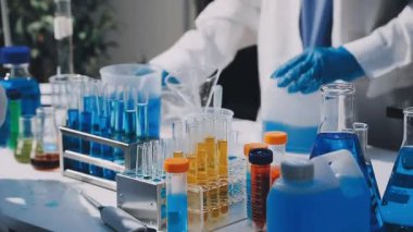 Laboratuvarda cam eşyalar ve kimyasal tüpler var..