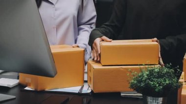 Ofiste dizüstü bilgisayarı ve kutuları olan bir kadın..