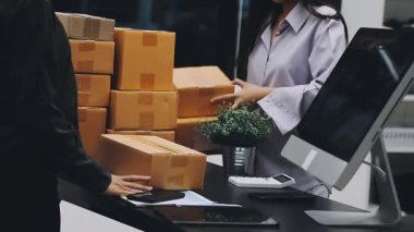 Ofisteki teslimat servisi için akıllı telefonu kullanan genç bir kadın.
