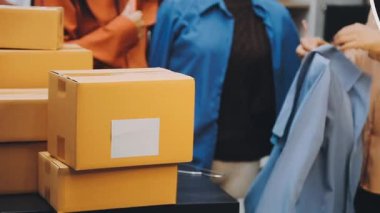 Karton kutularla giyim mağazasında bir kadın.