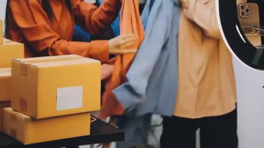 Mavi gömlekli kadın eli, modern mağazada ya da mağazada bir sürü paket bulunan karton kutuları tutuyor..