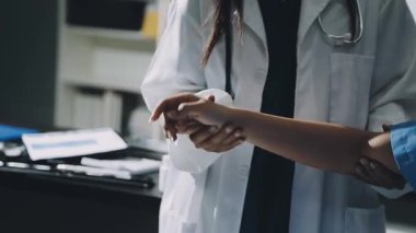 Kapalı - hastanede hastanın kolunu tutan doktorun fotoğrafı.