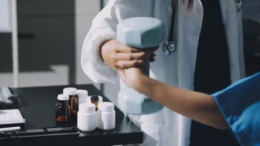 Beyaz üniformalı doktor elinde steteskop tutuyor.